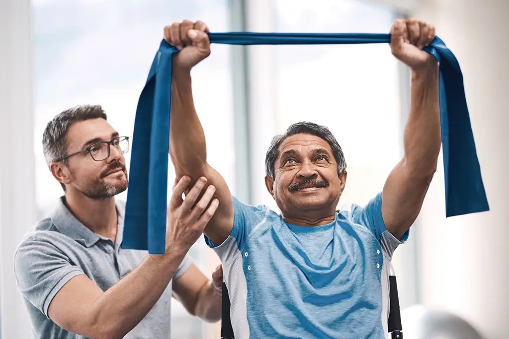 A senior man working on resistance training with a respite caregiver.